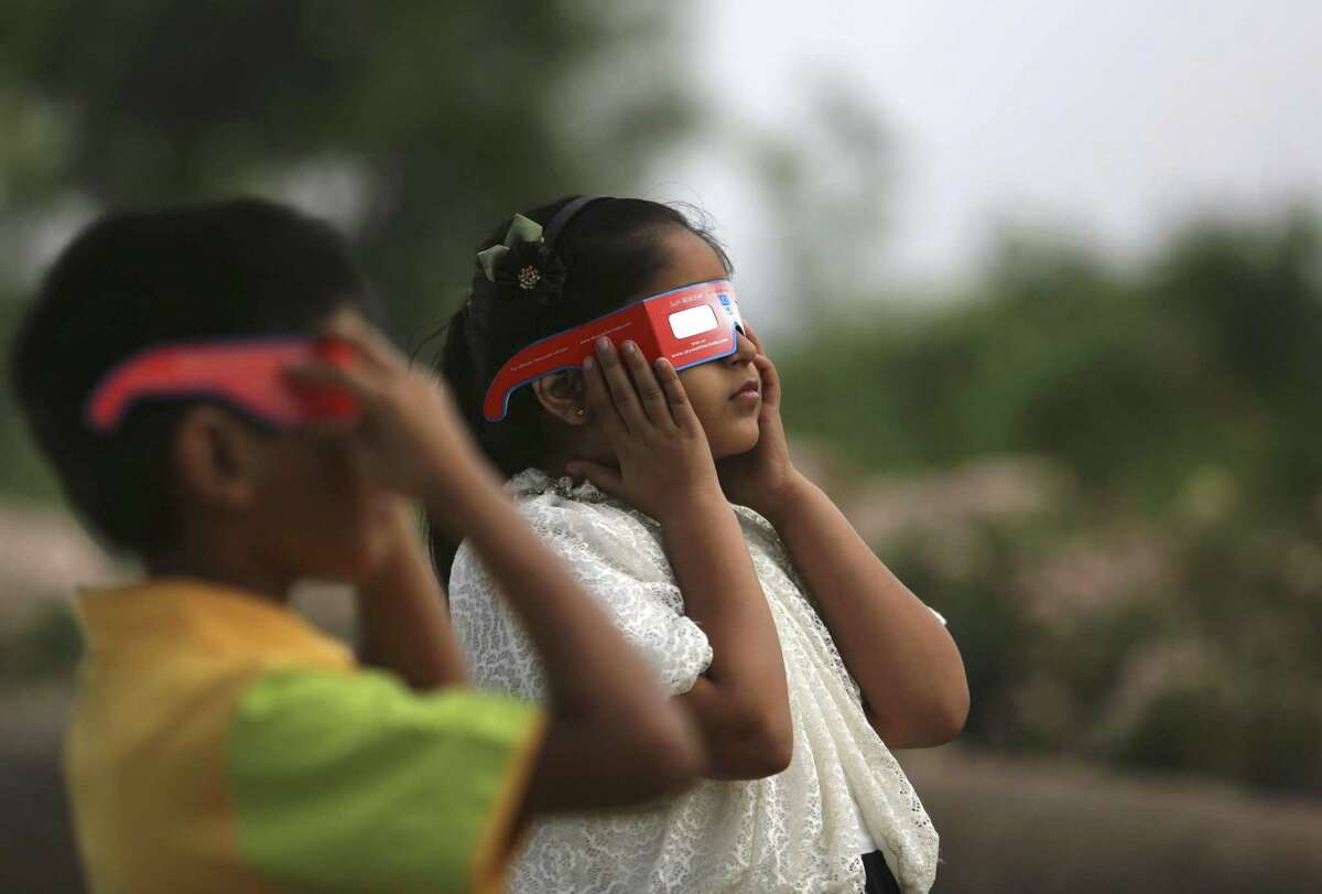 The safest way to directly view an eclipse is through special-purpose solar eclipse glasses that filter out harmful UV rays. Look for eclipse glasses that comply with the ISO 12312-2 international safety standard. Here children watch a partial solar eclipse in Hyderabad, India in 2016.
