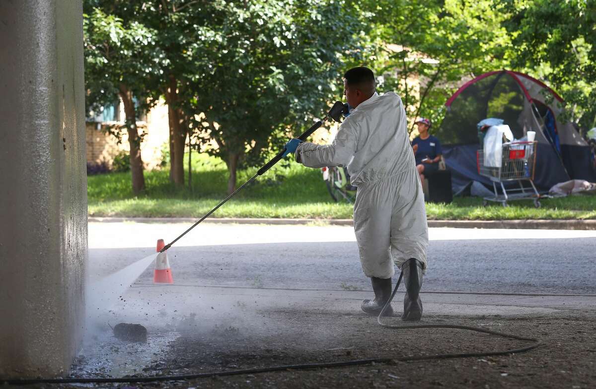 A worker power washes a Highway 59 pillar after city officials evacuated a homeless encampment due to serious health hazards under the Highway 59 overpass, between Caroline and La Branch streets Thursday, Aug. 10, 2017, in Houston. People will be able to return once the city is done with cleanup of the area. ( Godofredo A. Vasquez / Houston Chronicle )