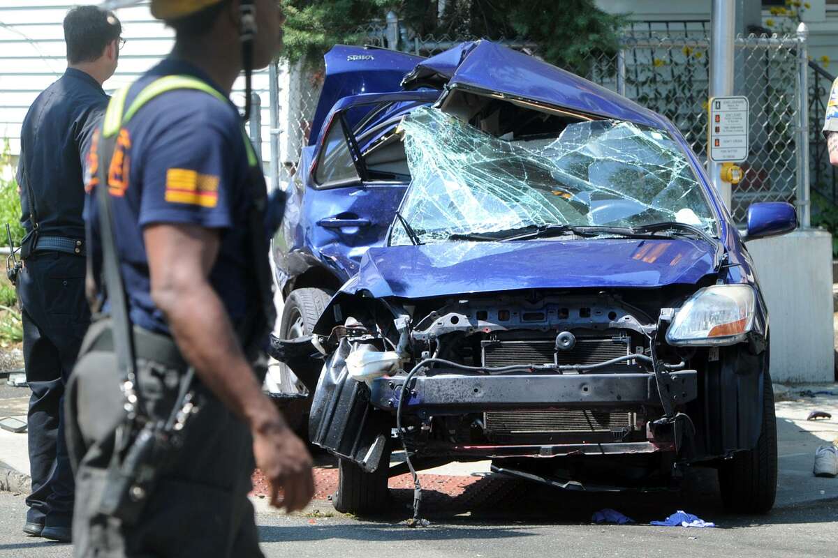 The scene at the intersection of Iranistan and Railroad Avenues following a fatal accident involving a Toyota Yaris, pictured here, which was hit by another vehicle, not pictured, that was being pursued by State Police in Bridgeport, Conn. Aug. 10, 2017.