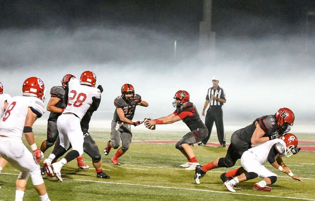 Hargrave Quarterback Dylan Lorfing hands the ball off to running back Camron McMahan
