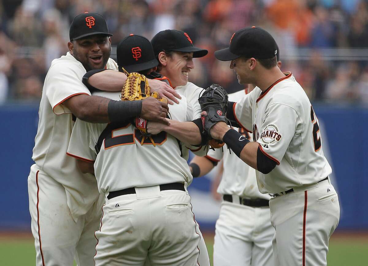 San Francisco Giants pitcher Tim Lincecum, center, is embraced by teammates, from left, Pablo Sandoval, catcher Hector Sanchez, and Buster Posey after throwing a no-hitter against the San Diego Padres a baseball game Wednesday, June 25, 2014, in San Francisco. Lincecum threw his second career no-hitter as San Francisco won 4-0. (AP Photo/Eric Risberg)
