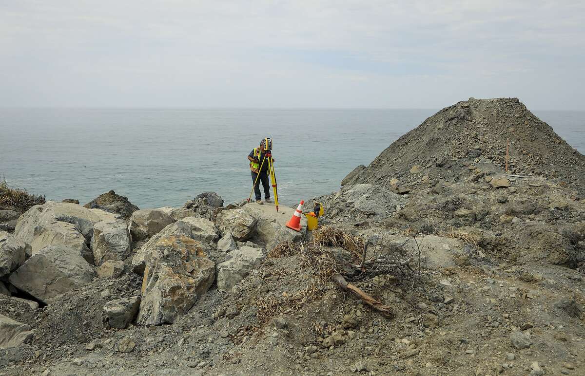 Bob Brown, with Caltrans, monitors boulders for movement high up on the Mud Creek slide near Gorda, Calif., Thursday, Aug. 3, 2017. California officials say they'll build a road over the massive Central Coast landslide that closed the scenic coastal highway leading to Big Sur. The Department of Transportation announced Tuesday that spanning the Mud Creek site will be a faster and cheaper way of reopening Highway 1, compared to boring a tunnel or sidestepping the slide area. (Joe Johnston /The Tribune (of San Luis Obispo) via AP)