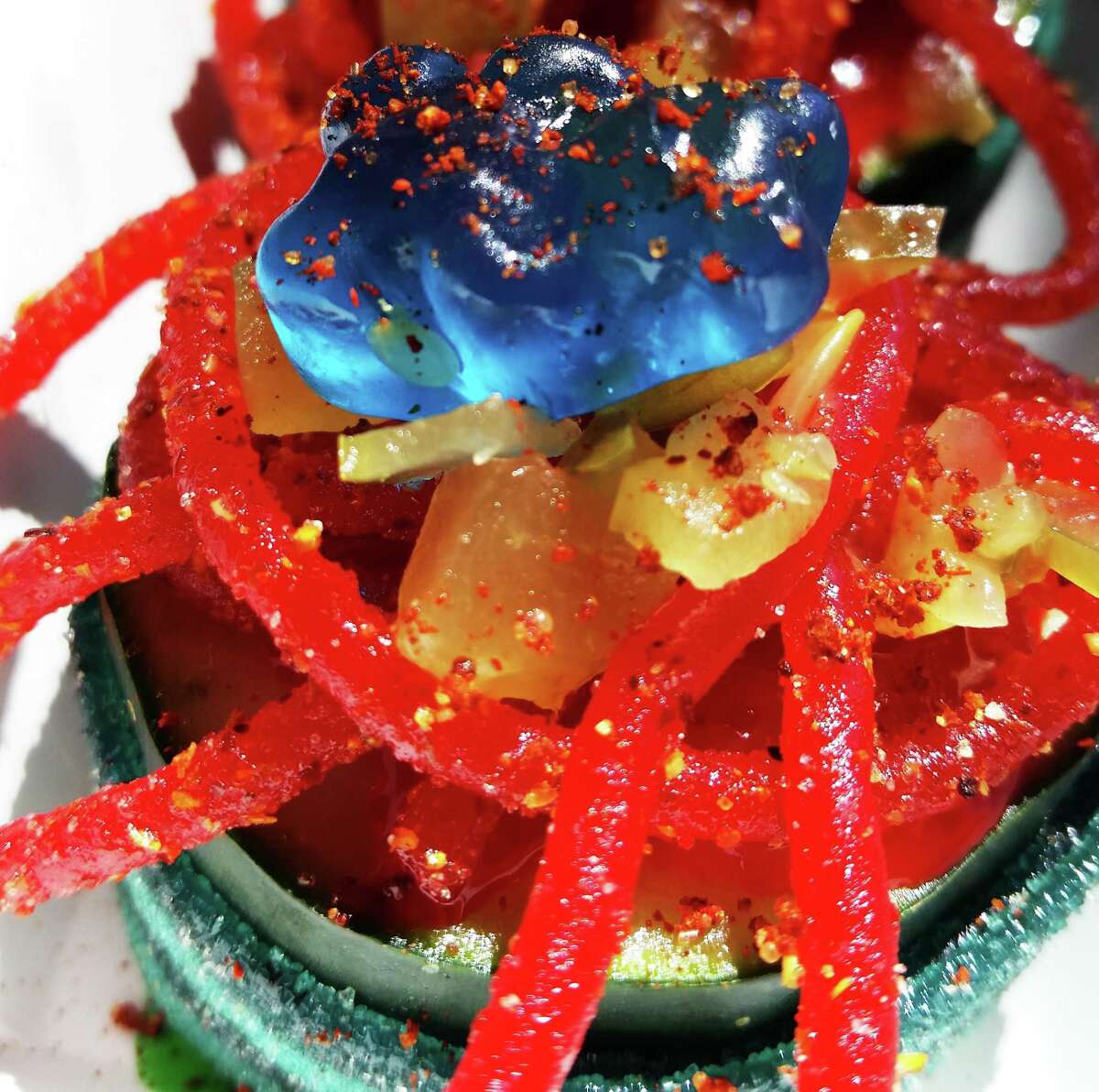 The Cucumber Sushi raspa from Chamoy City Limits is garnished with chopped pickled fruits, candy and chamoy sauce.