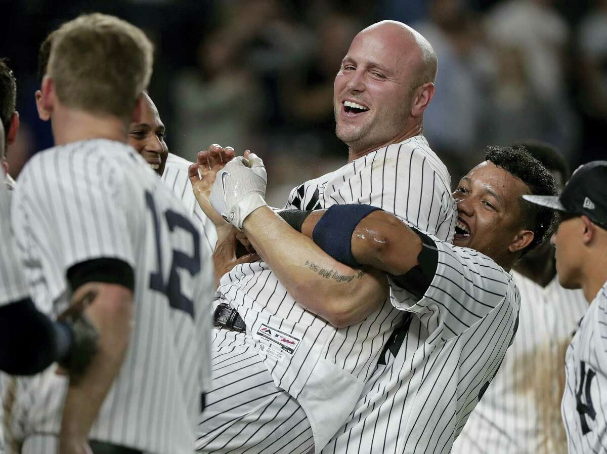 New York Yankees’ Starlin Castro, right, hugs Matt Holliday after Holliday hit a three-run home rung during the tenth inning of a baseball game to beat the Baltimore Orioles, Friday, April 28, 2017, in New York. (AP Photo/Julie Jacobson)