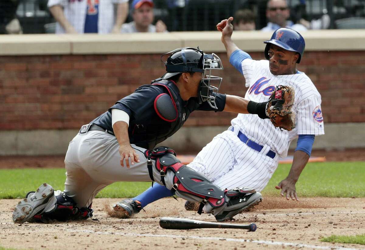 New York Mets' David Wright, center, slides into third base after