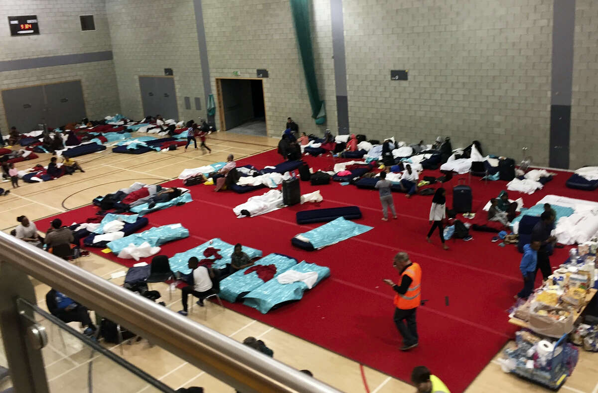 People gather in a leisure centre in Swiss Cottage, north London, Saturday June 24, 2017, after the local council evacuated some 650 homes overnight. Camden Borough Council said in a statement Saturday that it housed many of the residents at two temporary shelters while many others were provided hotel rooms, after inspectors found fire safety issues in housing towers, following the inferno in a west London apartment block that killed 79.