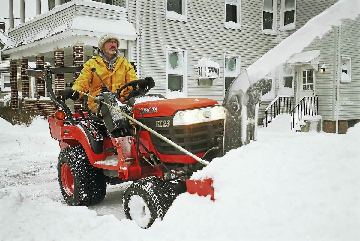 Ed Amato aboard his Kubota RX23 to plow the sidewalk on Pearl Street in Middletown on Thursday.