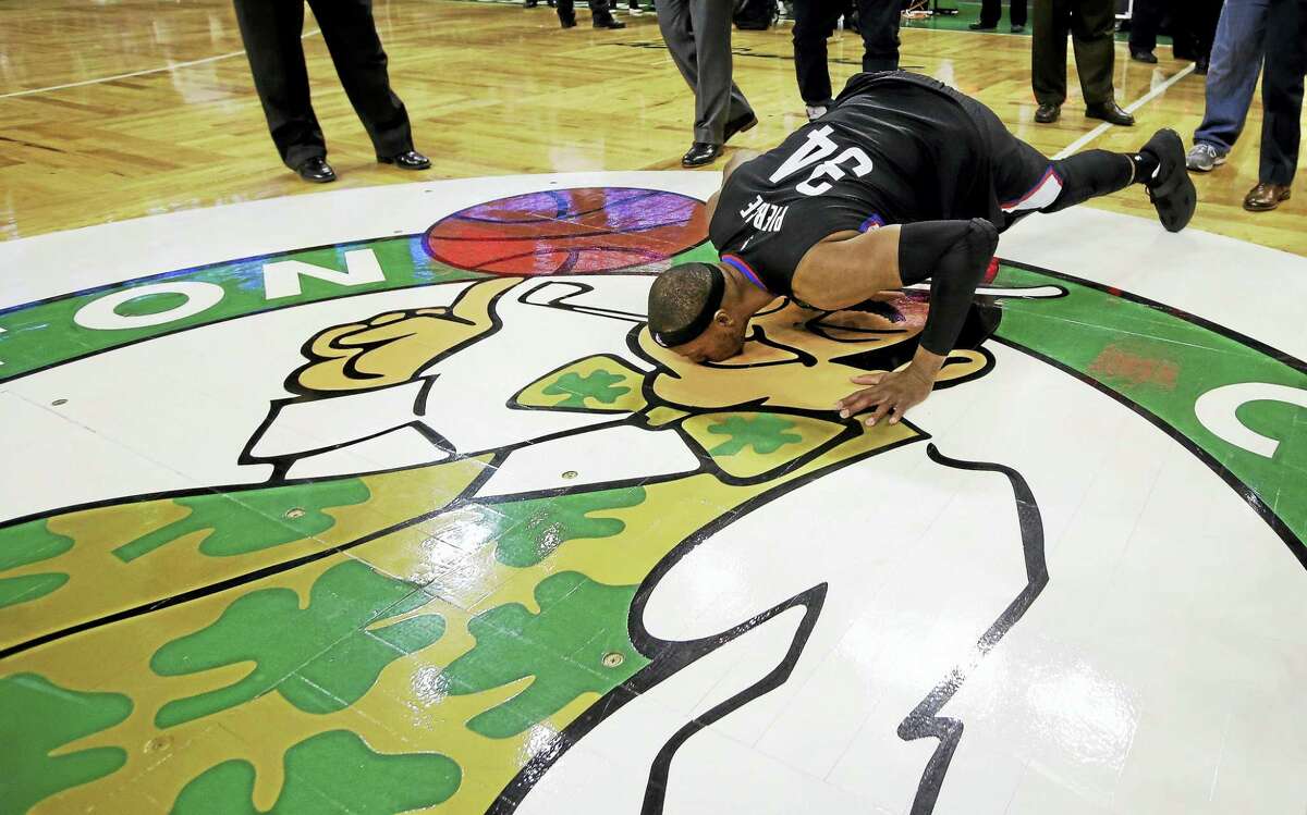 Paul Pierce, as a member of the Clippers, bends down to kiss the Boston Celtics logo following his final game in Boston.