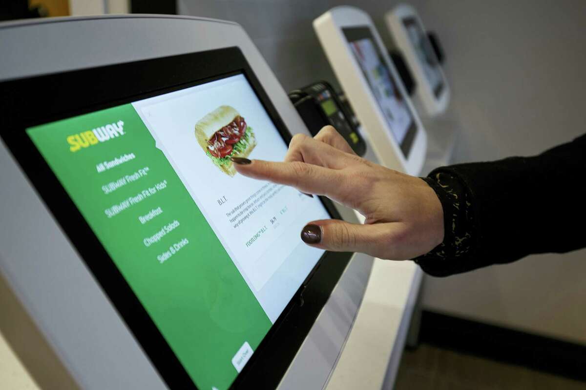 This January 2017 photo provided by Subway shows the use of new ordering tablets at a remodeled Subway store in Knoxville, Tenn. Subway is looking to update the look of its stores as the chain’s U.S. sales have been declining. The company says the redesign, which includes a brighter atmosphere, displays of vegetables behind the counter and ordering tablets, is the first major revamp since the early 2000s. (Chris Radcliffe/Subway via AP)