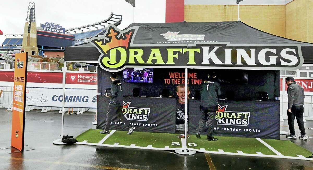 Workers set up a DraftKings promotions tent in the parking lot of Gillette Stadium, in Foxborough, Mass.