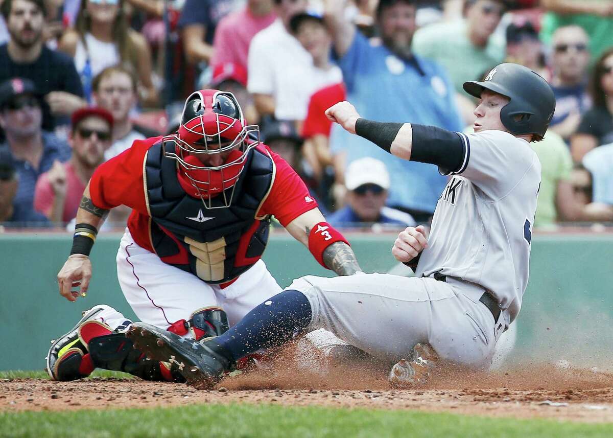 The Yankees’ Clint Frazier, right, scores during the fourth inning of the first game of a doubleheader in Boston on Sunday.