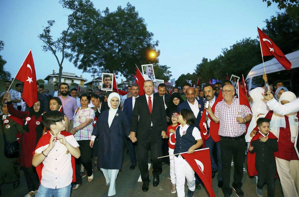 Turkey’s President Recep Tayyip Erdogan, centre, accompanied by his wife Emine, left, march with relatives of victims of the July 15, 2016, failed coup attempt, as he arrives close to the July 15 Martyr’s bridge to commemorate the one year anniversary of the coup attempt, in Istanbul, Saturday, July 15, 2017. Turkey commemorates the first anniversary of the July 15 failed military attempt to overthrow Erdogan, with a series of events honoring some 250 people, who were killed across Turkey while trying to oppose coup-plotters.