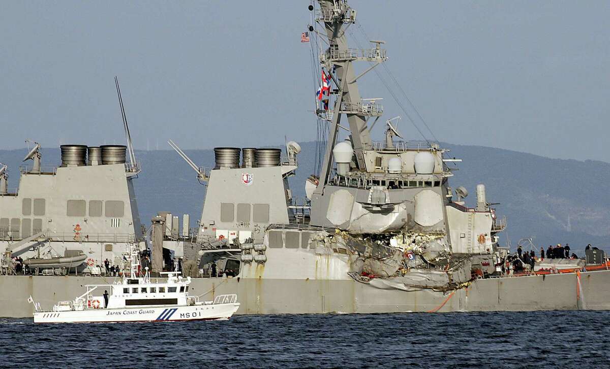A Japan Coast Guard baot goes along with the damaged USS Fitzgerald near the U.S. Naval base in Yokosuka, southwest of Tokyo, after the U.S. destroyer collided with the Philippine-registered container ship ACX Crystal in the waters off the Izu Peninsula Saturday, June 17, 2017. Crew members from the destroyer USS Dewey were helping stabilize the damaged USS Fitzgerald after its collision off the coast of Japan before dawn Saturday, leaving seven sailors missing and at least three injured.