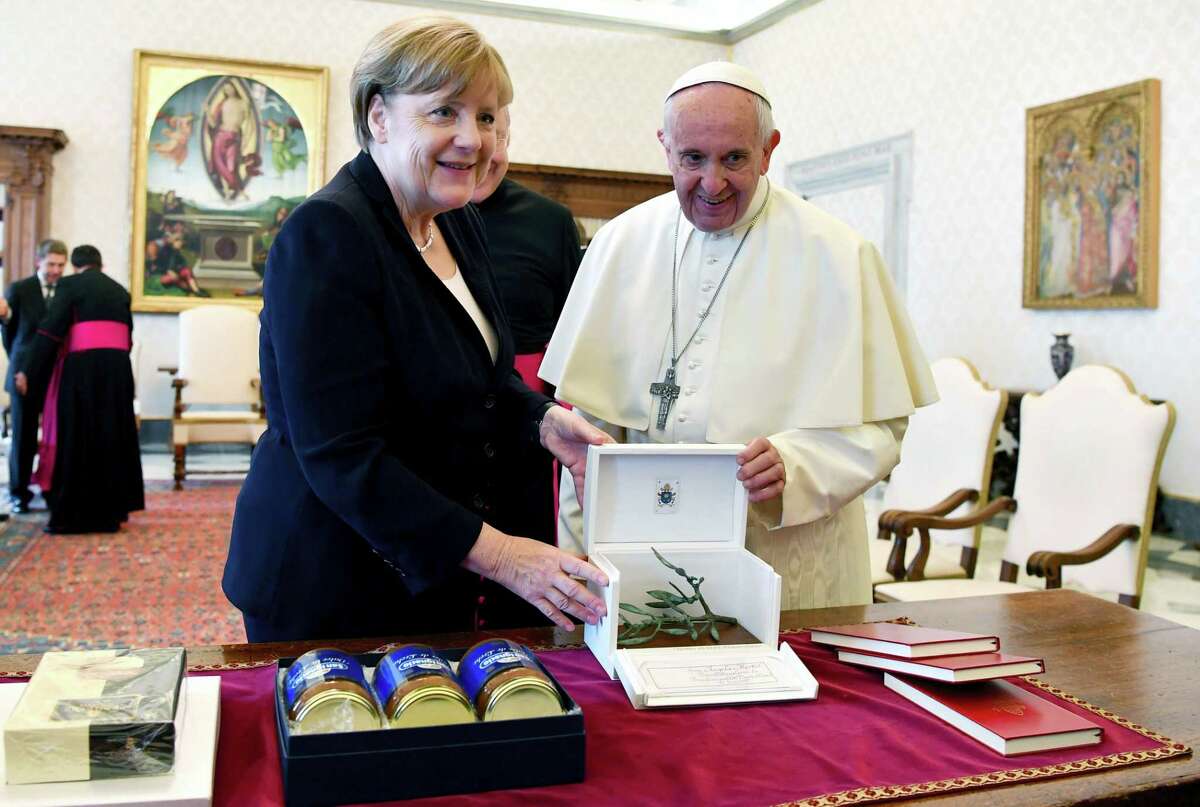 Pope Francis and German Chancellor Angela Merkel exchange gifts on the occasion of their private audience, at the Vatican, Saturday, June 17, 2017.