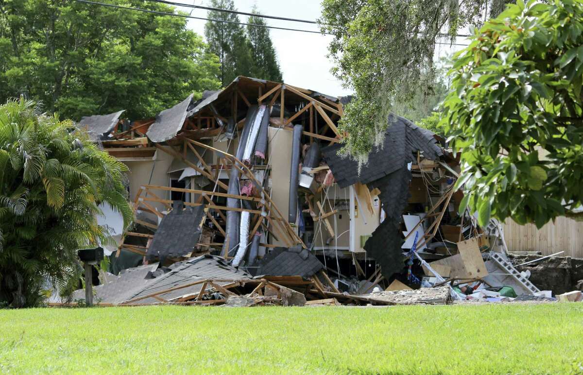 Debris is strewn about from a partially collapsed home in Land O’ Lakes, Fla. on Friday, July 14, 2017.A sinkhole that started out the size of a small swimming pool and continued to grow has swallowed a home in Florida and severely damaged another.