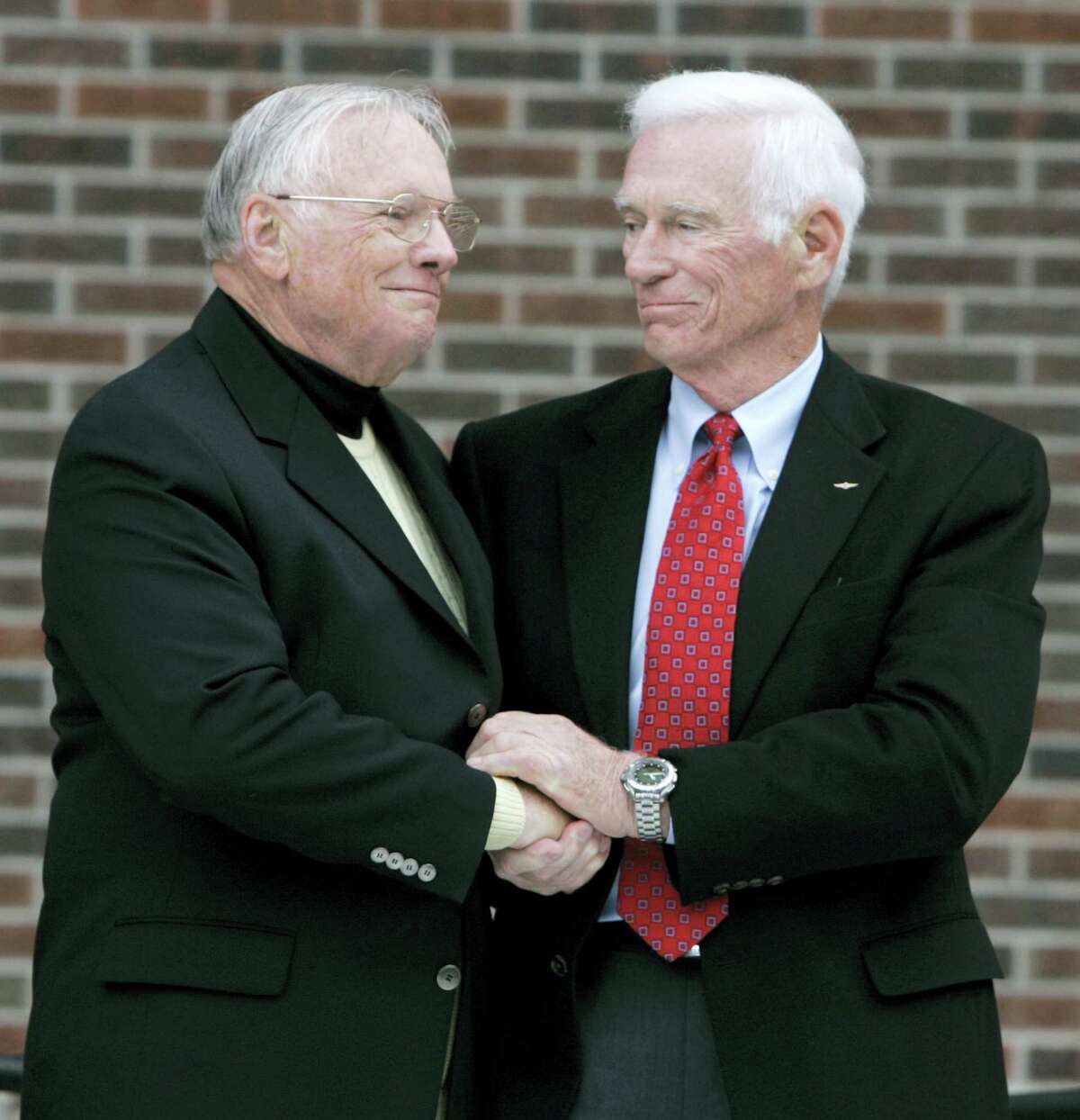 FILE - In a Oct. 27, 2007 file photo, former astronaut Neil Armstrong, left, is congratulated by fellow ex-astronaut Gene Cernan following the dedication ceremony of the Neil Armstrong Hall of Engineering at Purdue University in West Lafayette, Ind. NASA announced that former astronaut Gene Cernan, the last man to walk on the moon, died Monday, Jan. 16, 2017, surrounded by his family. He was 82.