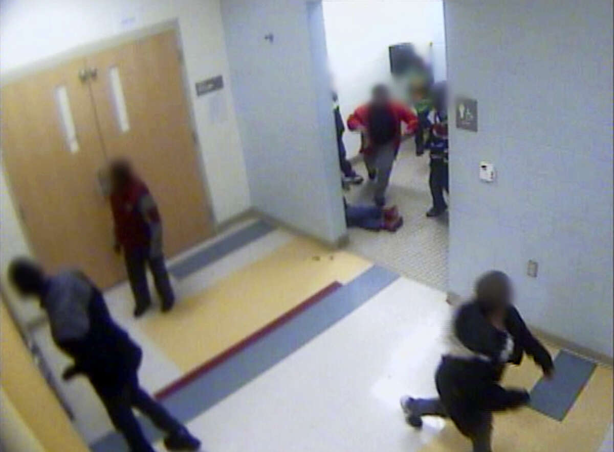 In this still image from a Jan. 24, 2017, surveillance video provided by Cincinnati Public Schools, the legs and feet of 8-year-old Gabriel Taye can be seen as he lies on the floor of a boys’ bathroom after being knocked unconscious by another boy at Carson Elementary School. Two days later, Taye hanged himself with a necktie in the bedroom of his Cincinnati apartment. (Cincinnati Public Schools via AP)