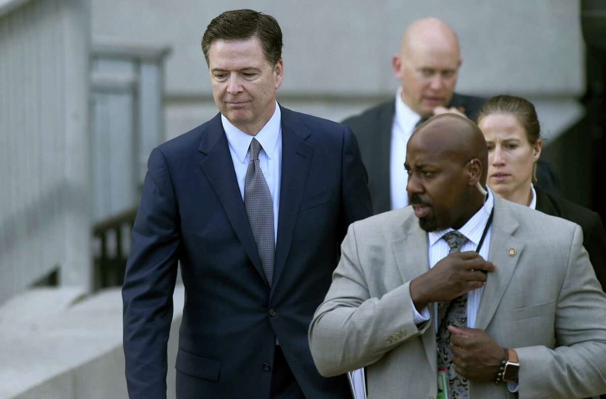 FBI Director James Comey, left, leaves the Eisenhower Executive Office Building on the White House complex in Washington.