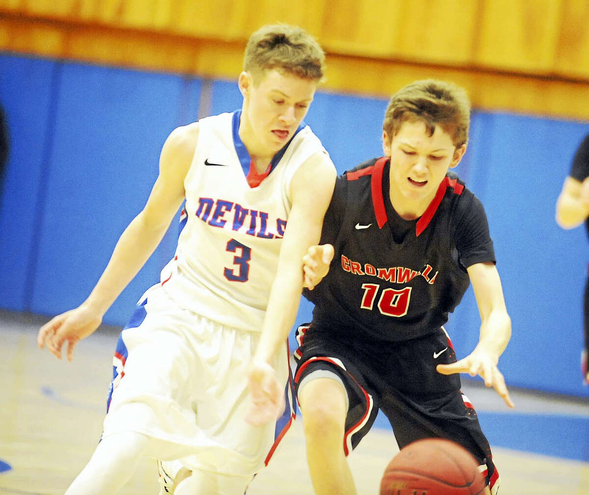 Coginchaug’s Ryan Cross, left, and Cromwell’s Noah Budzik fight for a loose ball in the Blue Devils’ 58-45 win Friday.