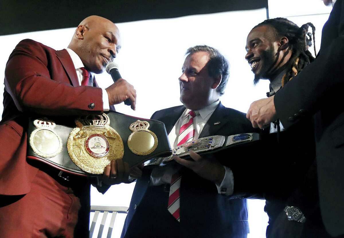 New Jersey Gov. Chris Christie, center, is presented with a belt by boxer Mike Tyson, left, for Christie’s work in promoting help for ex-prisoners re-entering society.