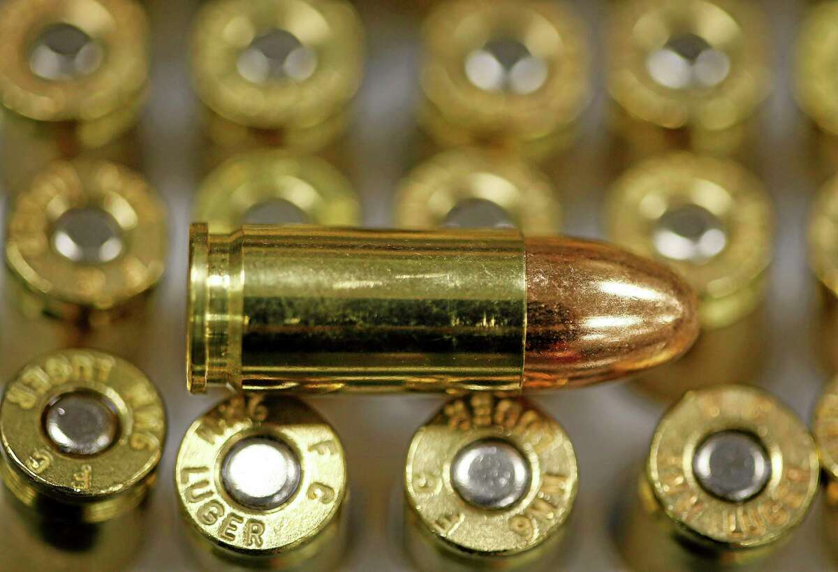 A 9 mm bullet rests on top of others in a box on the counter at Duke’s Sport Shop in New Castle, Pa., in 2013.