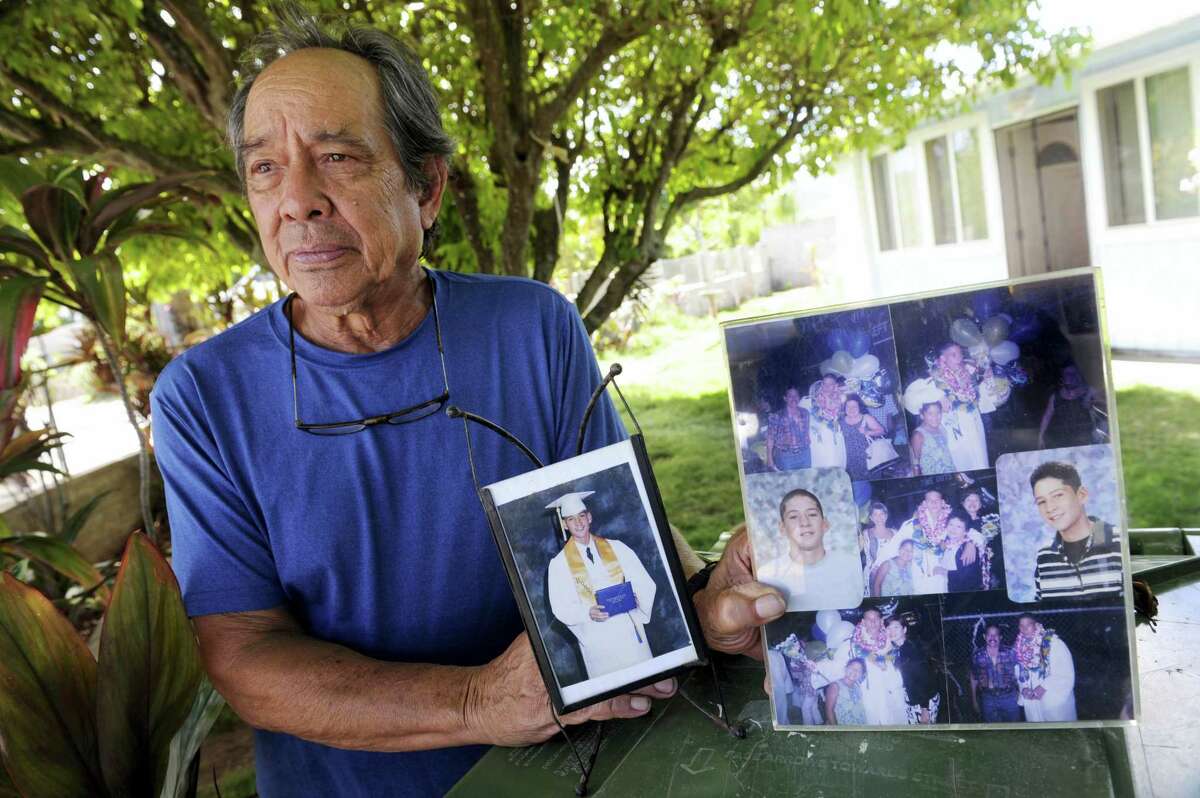 In this Monday, July 10, 2017 photo, Clifford Kang, father of soldier Ikaika E. Kang, poses with photo of his son in Kailua, Hawaii. Ikaika E. Kang, an active-duty U.S. soldier, was arrested over the weekend on terrorism charges that accuse him of pledging allegiance to the Islamic State group and saying he wanted to “kill a bunch of people.”