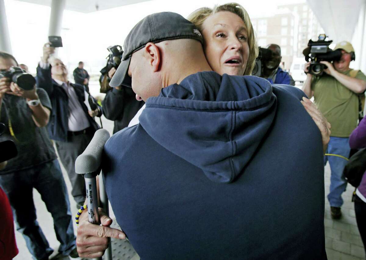 Boston Marathon bombing survivor Roseann Sdoia, from the North End neighborhood of Boston, is hugged and lifted off the ground by Boston firefighter Mike Meteria as she leaves Spaulding Rehabilitation Hospital in Boston in 2013.