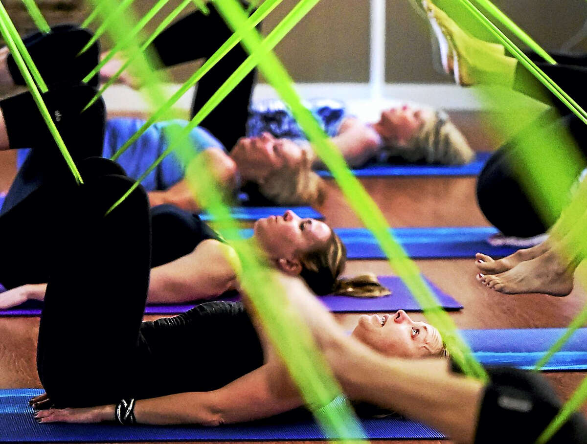 Dana Brown, operations director and fitness teacher, bottom, instructs clients during a cardio workout based on Pilates and barre principles called Barefoot Bands at Fitness on the Water in Westbrook.