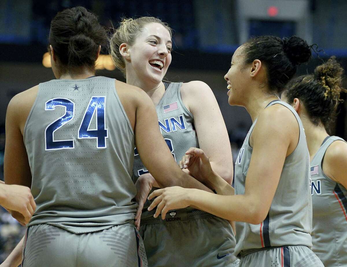UConn’s Katie Lou Samuelson, center, celebrates with teammates Napheesa Collier, left, and Saniya Chong, right, in the first half of an NCAA college basketball game against South Florida Tuesday in Hartford. UConn beta South Florida 102-37 for its 90th straight victory, tying its own record.