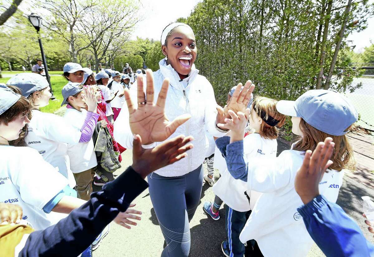 Professional tennis player Sloane Stephens (center) share high-fives with third graders from New Haven Public Schools during a free tennis clinic at the Connecticut Tennis Center courts in New Haven Tuesday.