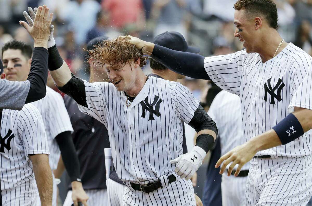 The Yankees’ Clint Frazier, center, is congratulated by teammates after hitting a three-run walk-off home run during the ninth inning against the Brewers Saturday at Yankee Stadium.