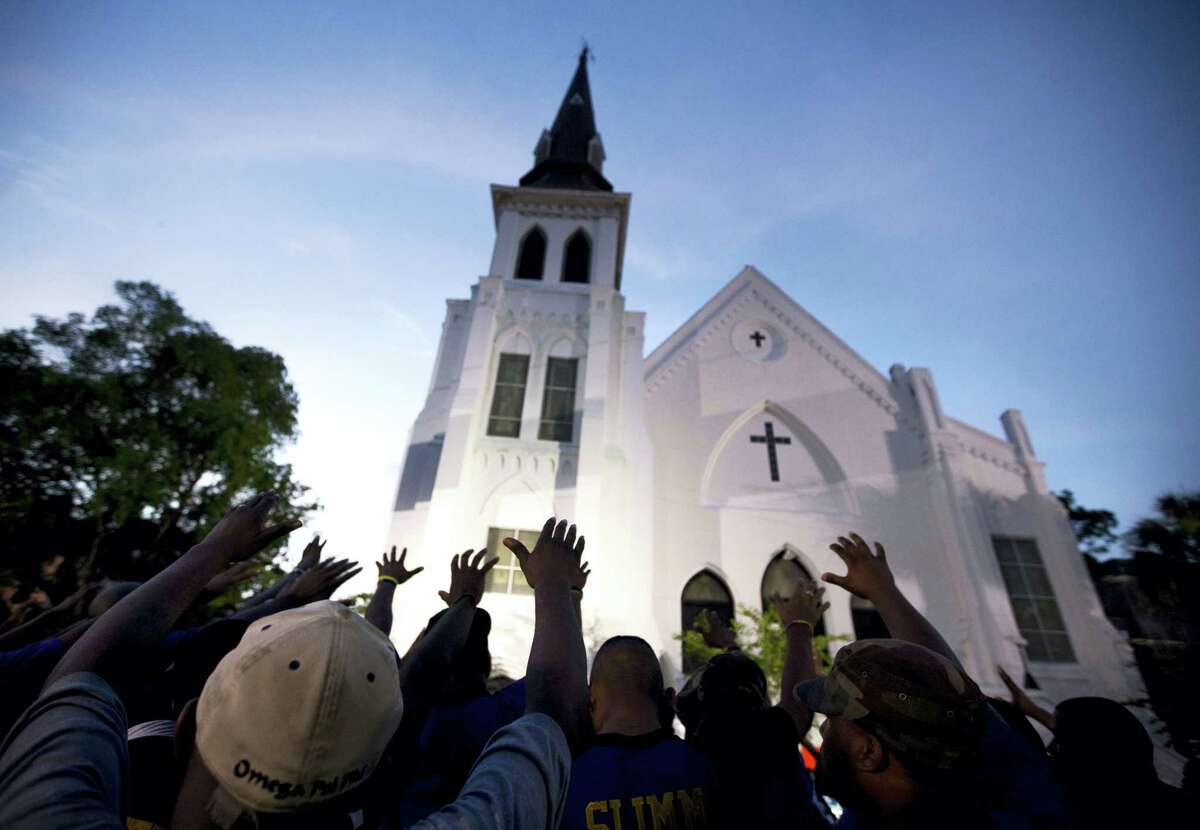 The men of Omega Psi Phi Fraternity Inc. lead a crowd of people in prayer outside the Emanuel AME Church, after a memorial for the nine people killed by Dylann Roof in Charleston, S.C.