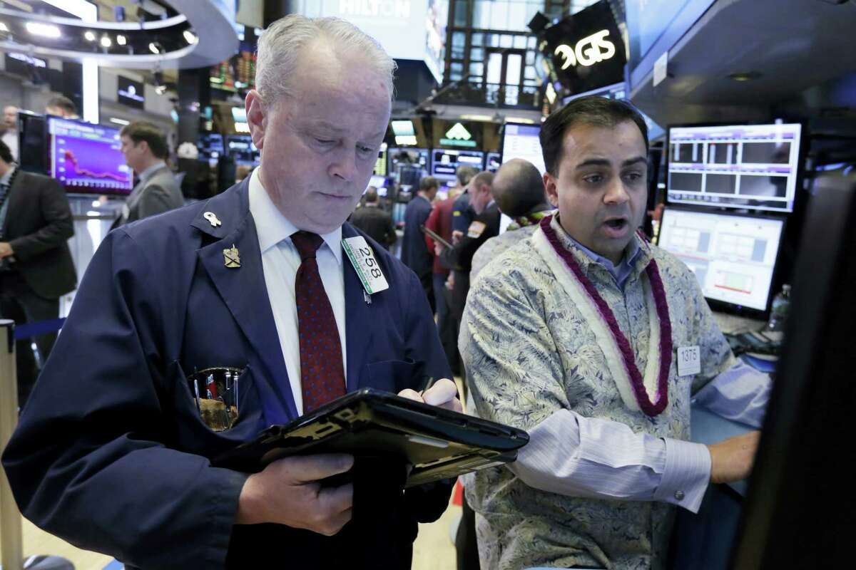 Trader James Riley, left, and specialist Dilip Patel work on the floor of the New York Stock Exchange Tuesday.