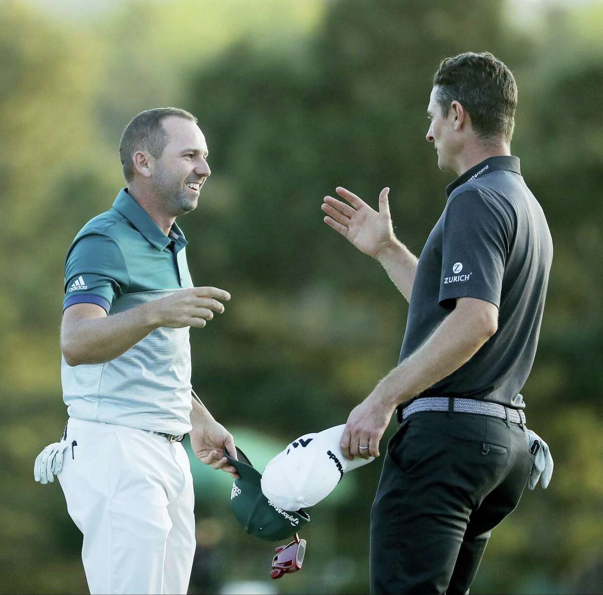 Sergio Garcia, of Spain, talks to Justin Rose, of England, after making his birdie putt on the 18th green to win the Masters golf tournament after a playoff Sunday in Augusta, Ga.