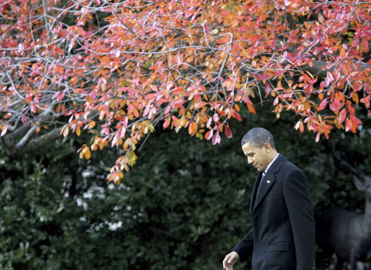 In this Dec. 6, 2010 photo, President Barack Obama walks across the South Lawn of the White House in Washington, to board Marine One helicopter as he travels to Winston-Salem, N.C. More than half of Americans view President Barack Obama favorably as he leaves office, a new poll shows, but Americans remain deeply divided over his legacy. Less than half of Americans say they’re better off eight years after his election or that Obama brought the country together.