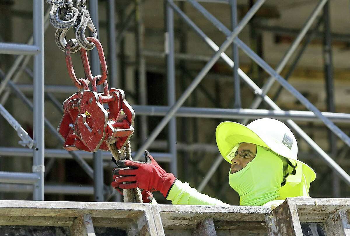 A construction worker continues work on a condominium project in Coral Gables, Fla. On Friday the Labor Department will release the U.S. jobs report for June.