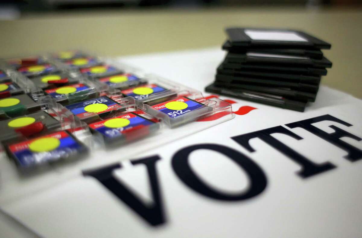 In this March 9, 2017 photo, a stack of zip disks and a tray of compact flash cards are seen at the Bexar County Elections office, in San Antonio. Bexar County’s voting equipment is among the oldest in America’s second-largest state and will have to be replaced soon. Election officials in states across the U.S. are eager to replace aging fleets of voting machines but are grappling with how to fund the nation’s next generation of voting equipment.
