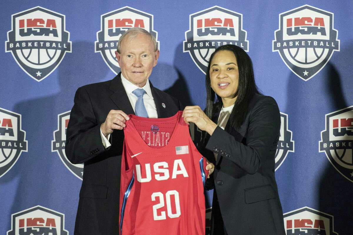 National Basketball Chairman Gen. Martin Dempsey, left, presents a jersey to South Carolina women’s head basketball coach Dawn Staley, right, during a press conference on Friday.