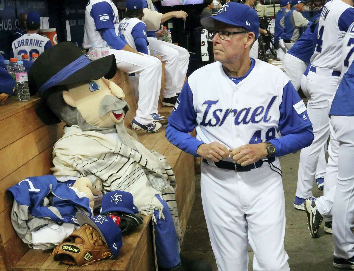 Israel’s third base coach Pat Doyle, right, passes by his team mascot, The Mensch on the Bench, during a first-round game of the World Baseball Classic in Seoul, South Korea.