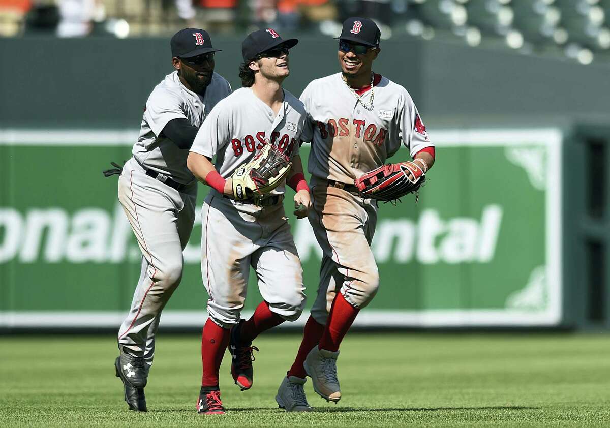 Red Sox outfielders, from left to right, Jackie Bradley Jr. Andrew Benintendi and Mookie Betts react after defeating the Orioles.