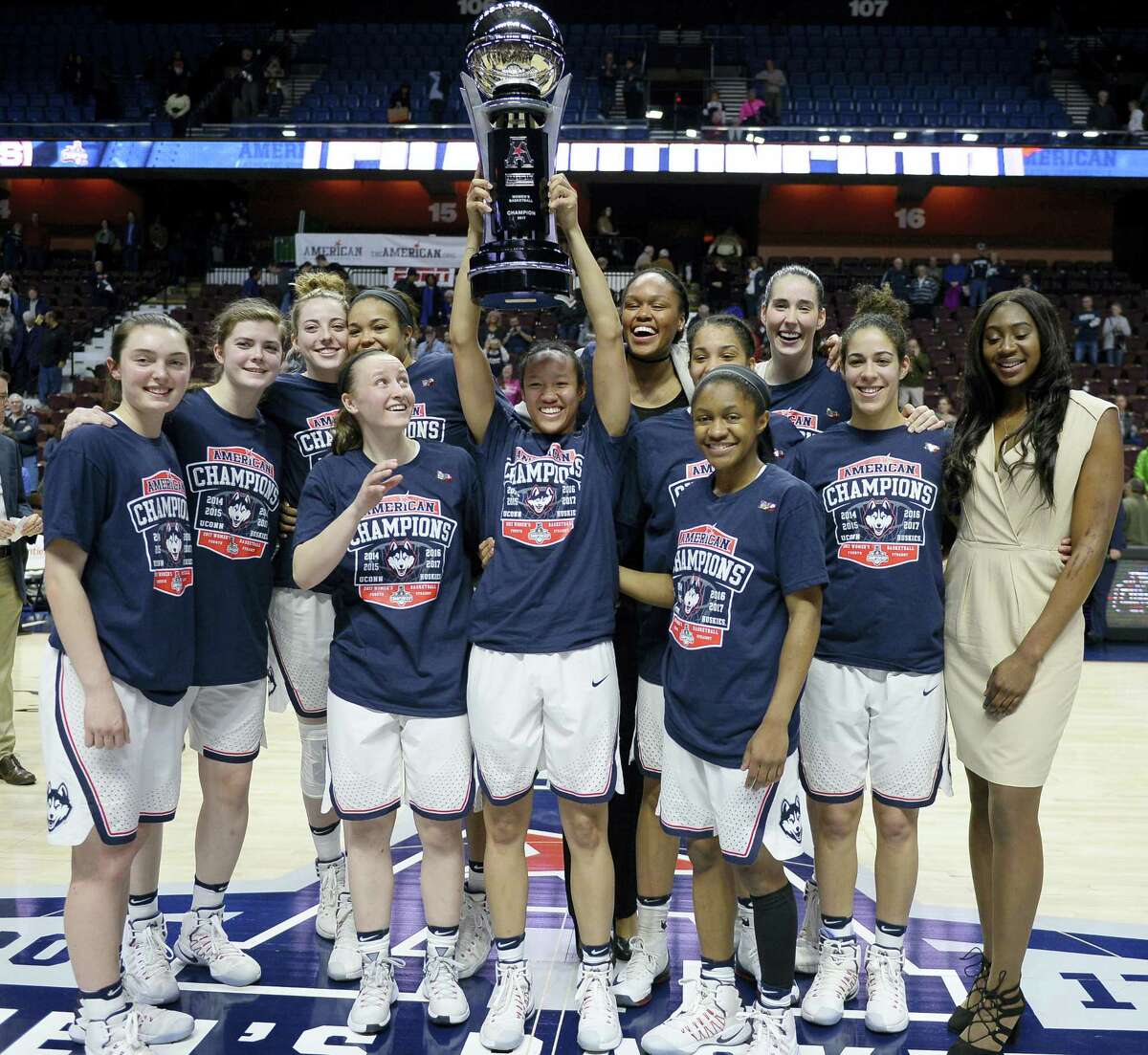 The UConn women’s basketball team pose with the American Athletic Conference championship trophy after defeating South Florida in the tournament final at the Mohegan Sun Arena Monday.