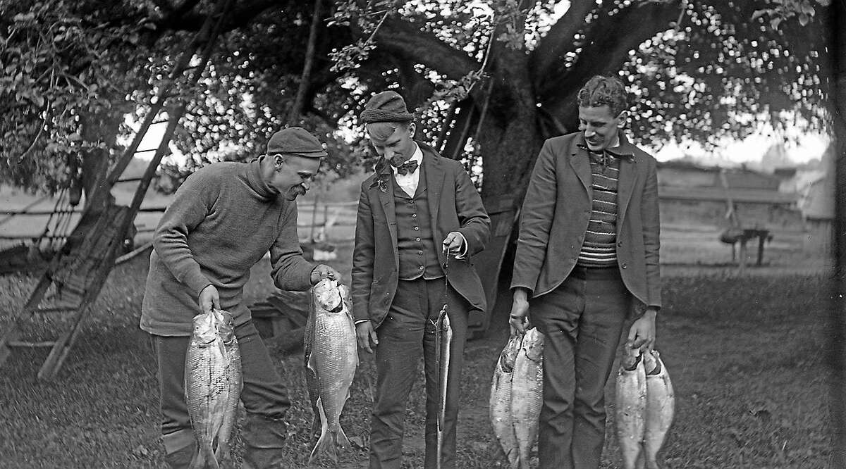 Shad Fisherman Admiring Their Catch, early 20th century photograph.