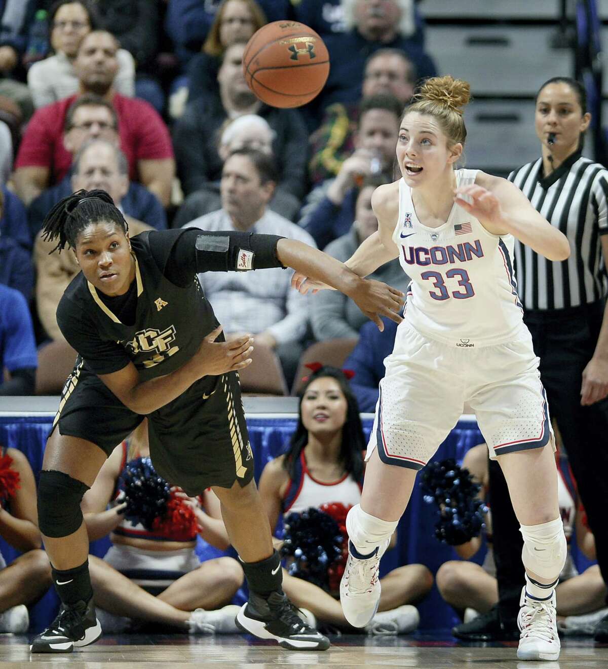 Central Florida’s Joslyn Massey, left, and UConn’s Katie Lou Samuelson, right, chase down a loose ball.