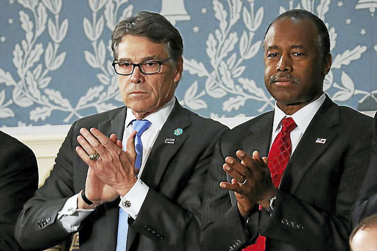Rick Perry, left, and Housing and Urban Development Secretary-designate Ben Carson applaud on Capitol Hill in Washington, Tuesday, Feb. 28, 2017, before President Donald Trump’s address to a joint session of Congress.