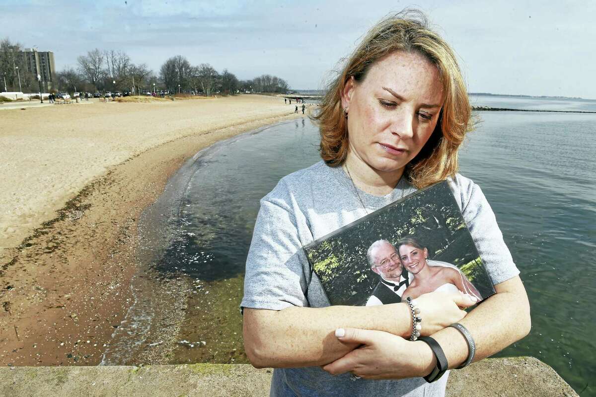 Lindsay Romano of Newington, who teaches eighth grade at Cromwell Middle School, holds a wedding photograph of herself with her late father, Bill Newberry, at the beach in the Savin Rock section of West Haven. She will be participating in the Connecticut Brain Freeze hosted by the National Brain Tumor Society on Sunday.