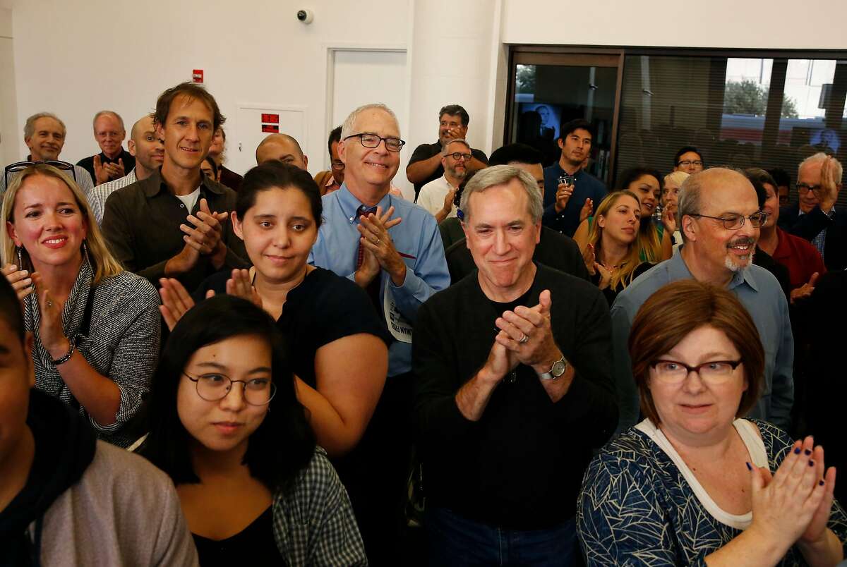 Current and former San Francisco Chronicle colleagues including Photo Editor Alex Washburn, center left, and Enterprise and Investigations Editor Michael Gray, center right, clap for David Perlman at a party recognizing the decades of work Perlman has accomplished while working for the San Francisco Chronicle August 11, 2017 at the Chronicle's headquarters in San Francisco, Calif.