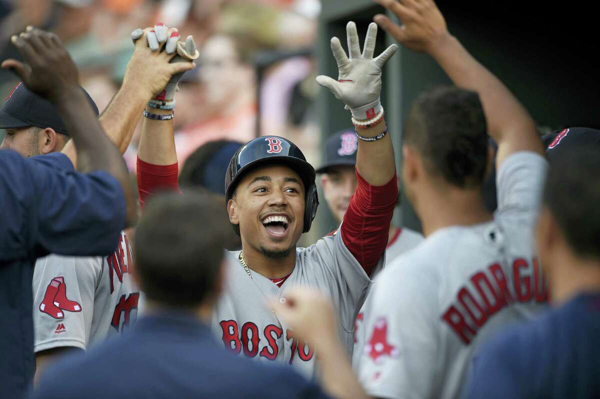 Boston Red Sox’ Mookie Betts celebrates his home run in the dugout during the first inning against the Baltimore Orioles, Tuesday, May 31, 2016, in Baltimore. Betts homered three times in the 6-2 victory.