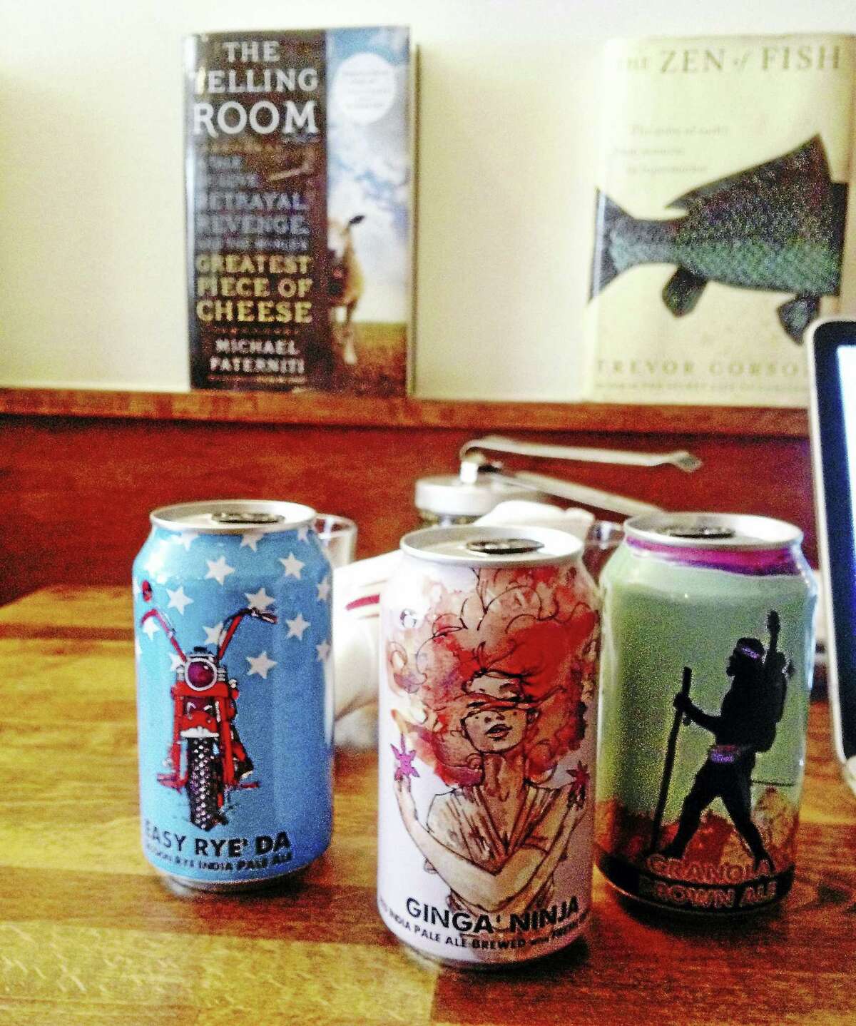 Three of the beer cans designed by Max Toth from left are Easy Rye’ Da, Ginga’ Ninja and Granola Brown Ale.