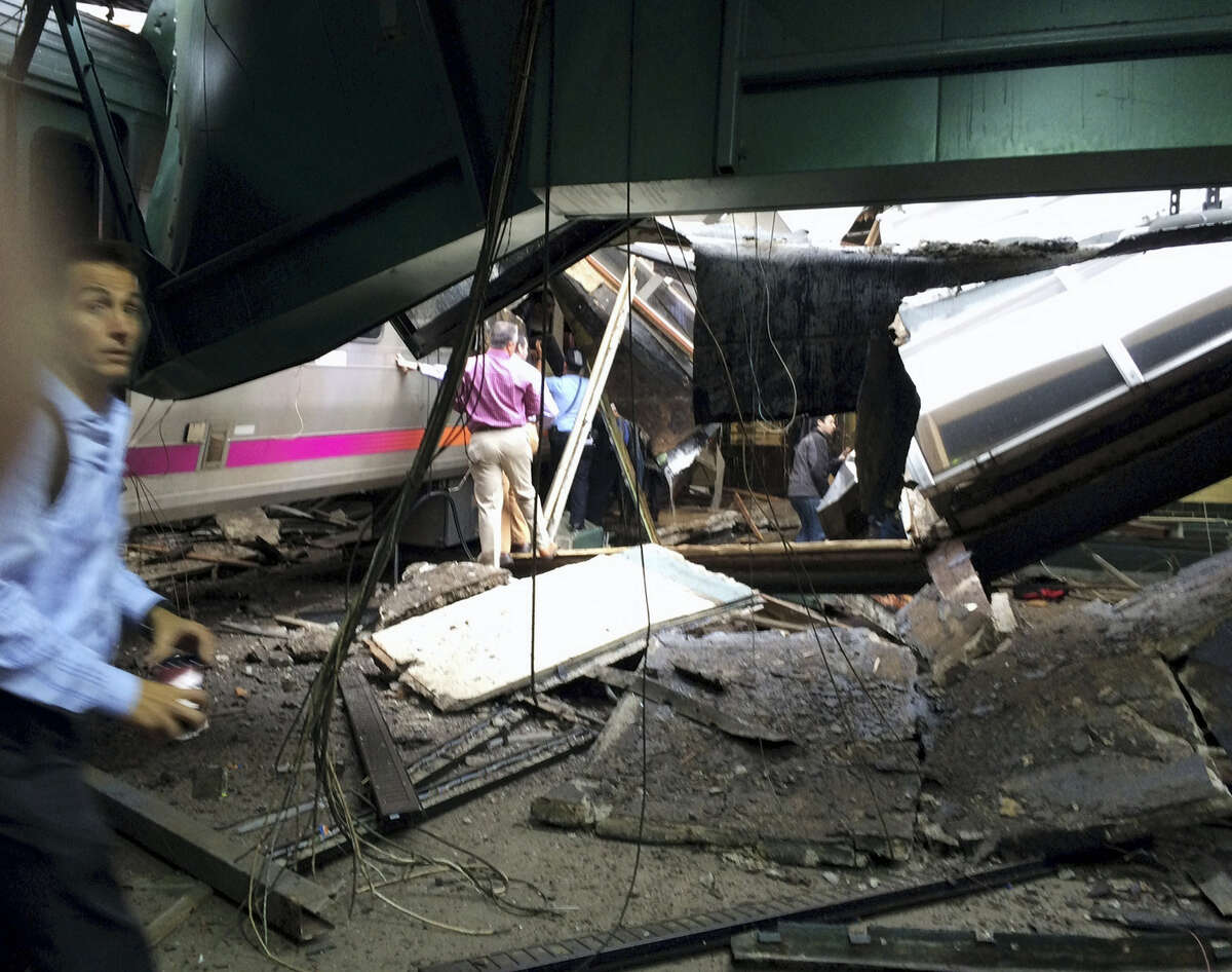 People examine the wreckage of a New Jersey Transit commuter train that crashed into the train station during the morning rush hour in Hoboken,, N.J., Thursday, Sept. 29, 2016.