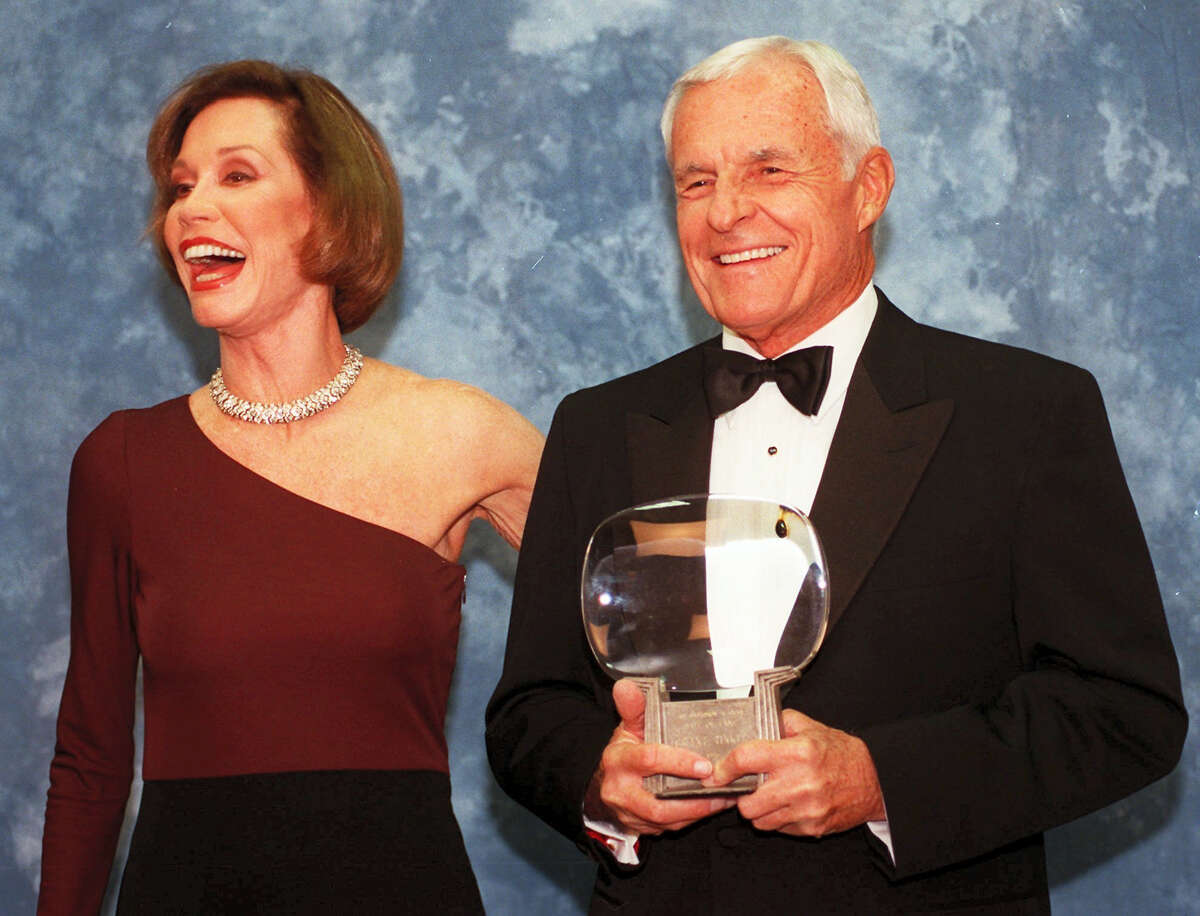 In this Saturday, Nov. 1, 1997, file photo, Television executive Grant Tinker holds up his Hall of Fame award alongside his ex-wife Mary Tyler Moore at the Academy of Television Arts & Sciences’ 13th Annual Hall of Fame induction ceremonies in the North Hollywood section of Los Angeles. Tinker, who brought “The Mary Tyler Moore Show” and other hits to the screen as a producer and a network boss, has died. Tinker died Monday, Nov. 28, 2016, at his home in Los Angeles, according to his son, Mark Tinker.